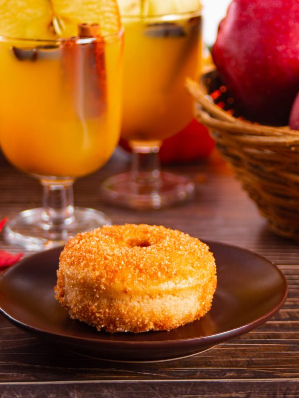 Sweet homemade apple cider donuts with cinnamon sugar on the wooden table. Autumn food.