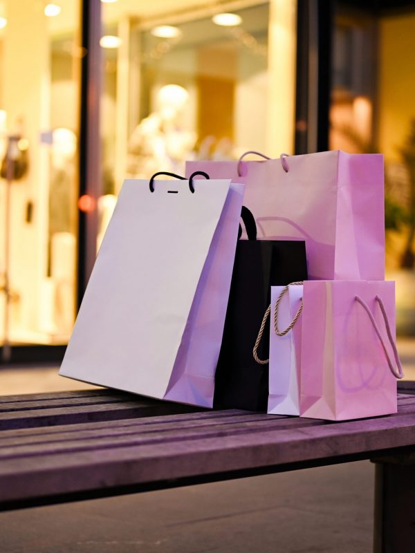 Shopping bags in front of store window.